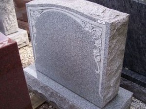 Gray granite monument with leaves at the upper corners