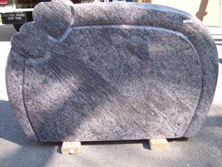 Gray granite monument with two yearts at the upper left corner