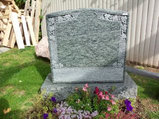 Gray granite monument with leaves in upper corners