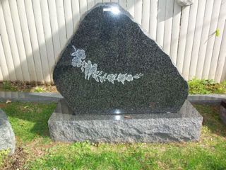 Gray granite monument with two birds on a branch