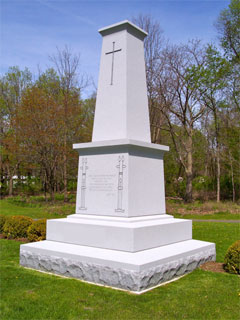 Gray granite monument with cross by Lutz Monument Company