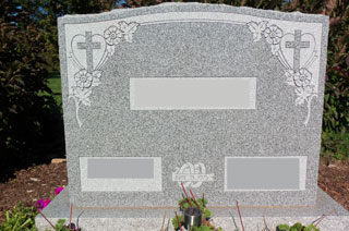 Gray granite double memorial with flowers and crosses at upper corners