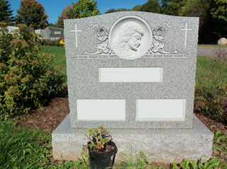 Double gray granite memorial with crosses at upper right corners and portrait at center top