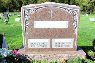 Double Granite Rose memorial with flowers in corners and cross in center