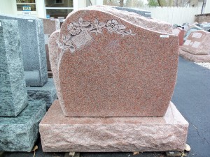 Mountain Rose granite monument with flowers and words In Gods Care at Karl Lutz Monument Company