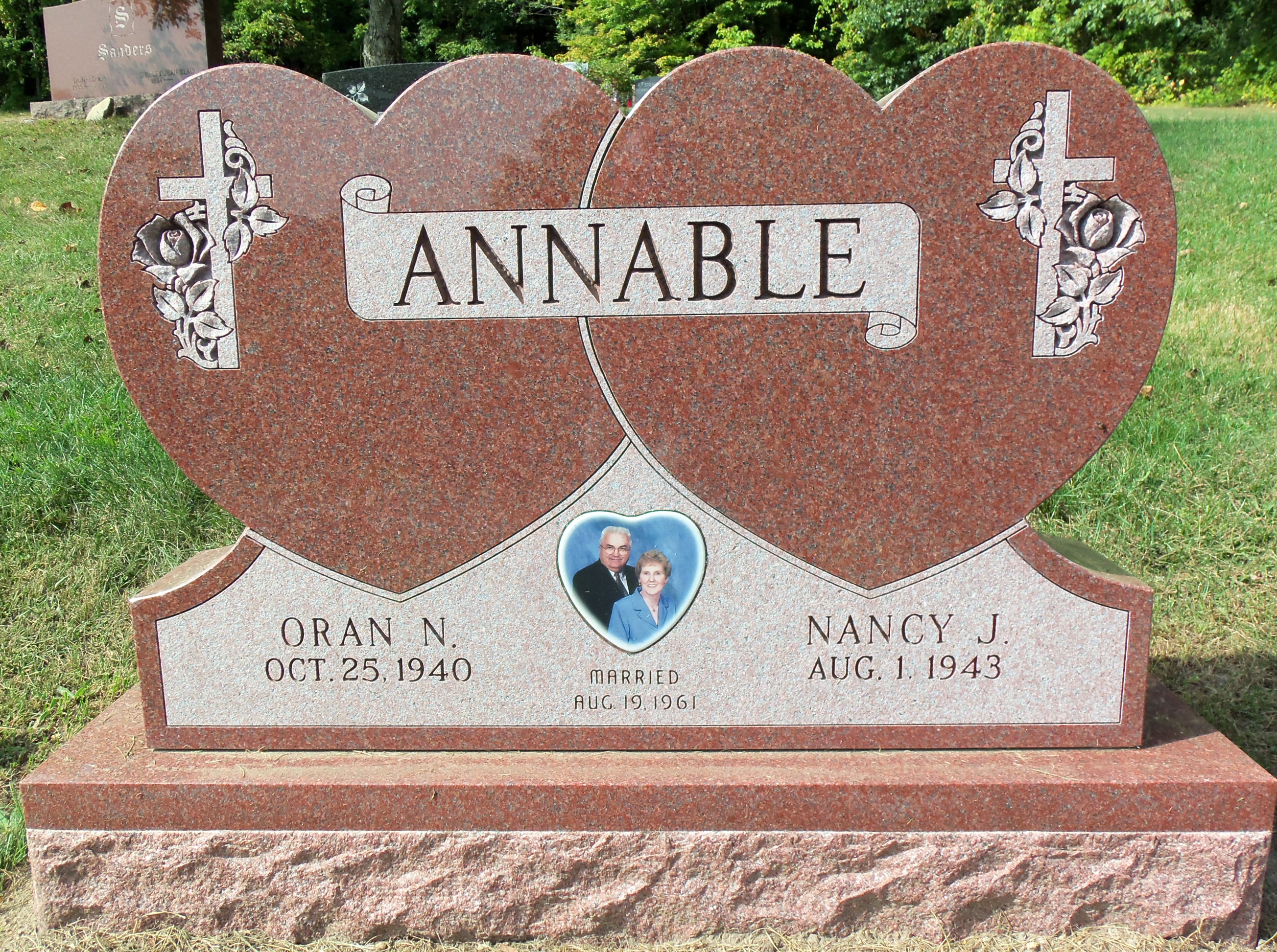 Mountain Rose granite memorial with joined hearts, crosses, and photo of the couple